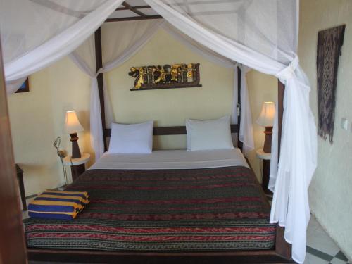 艾湄湾雅艾姆德Spa度假村的一间卧室配有一张带天蓬的床