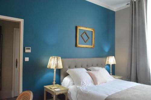 佩里格Villa Vesone的一间卧室设有蓝色墙壁、一张床和两盏灯。