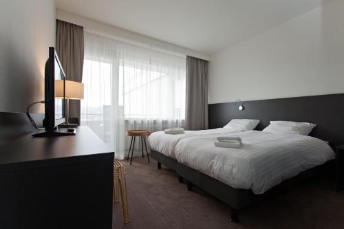 巴特拉斯费芳酒店的一间卧室配有一张床和一张书桌及电视