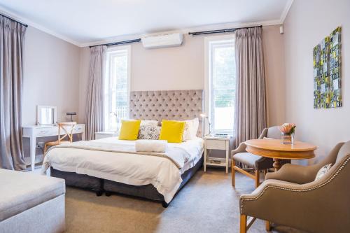 斯泰伦博斯博讷埃斯佩兰斯一室公寓的一间卧室配有一张带黄色枕头和桌子的床