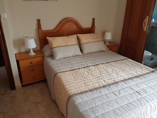 科巴罗港口之家酒店的一间卧室配有一张带2个床头柜和2盏灯的床。