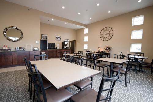 厄尔温Cornerstone Inn & Suites Oelwein的一间在房间内配有桌椅的餐厅