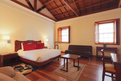 波哥大圣露西亚精品温泉酒店的一间卧室配有一张床、一张沙发和一张桌子