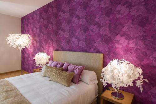 纳龙Hotel A Roldana的一间卧室设有紫色墙壁和一张带两盏灯的床