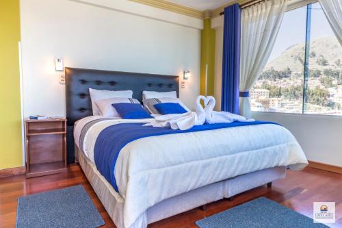 科帕卡巴纳拉戈阿祖尔酒店的一间卧室配有一张带蓝色和白色床单的床和窗户。