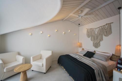 费特希耶Yacht Boheme Hotel-Boutique Class - Adults Only的一间卧室配有一张床和两把白色椅子