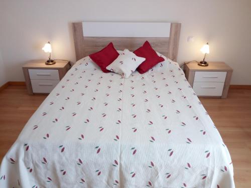 奥良Fun & Sun Apartment的一张带白色棉被和红色枕头的床