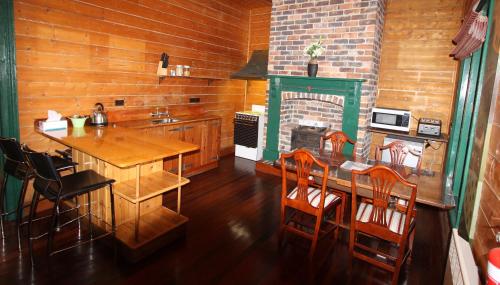 斯特拉恩Kerrellie Cottages 2, 4 & 8 Reid Street的厨房配有桌子和壁炉