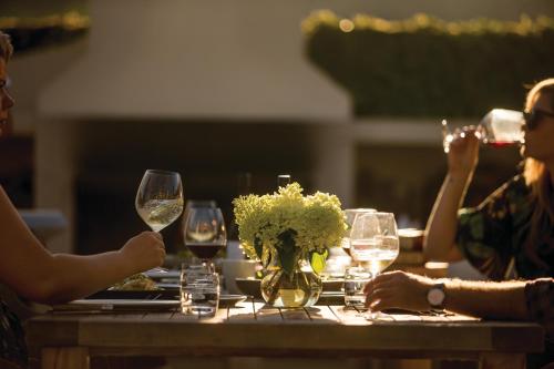 北哈夫洛克Craggy Range Luxury Vineyard Retreat的一群人坐在桌子旁,戴着酒杯