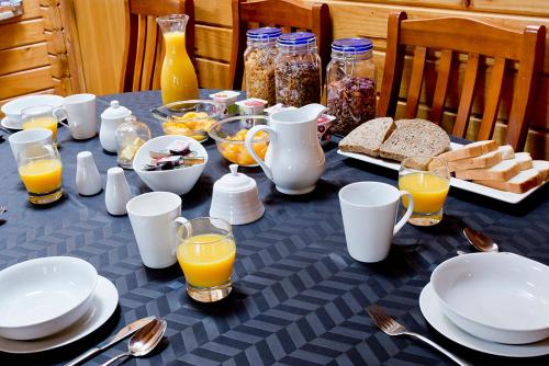 基督城旅客休闲住宿加早餐旅馆的餐桌上放有盘子和碗的食物和橙汁