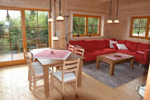 库罗阿尔滕堡Erzgebirgsholzhaus am Lugstein的客厅配有红色的沙发和桌子