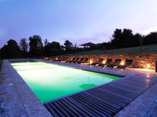 Thauron修道院旅馆的游泳池周围设有椅子,晚上