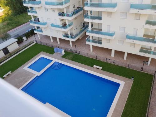 皮莱斯Apartamento playa Piles的享有带游泳池的公寓大楼的顶部景致
