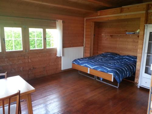 科莱恩斯普拉特Koningsheim的木制客房内的一间卧室,配有一张床