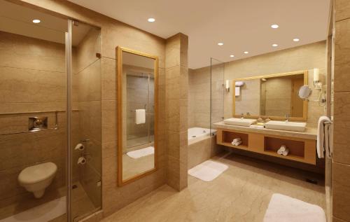 海得拉巴Lemon Tree Hotel, Gachibowli, Hyderabad的浴室配有卫生间、盥洗盆和淋浴。