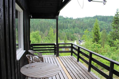 比尔克兰Bergheim Two-Bedroom Cottage的阳台的门廊配有长凳和桌子