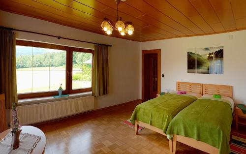 沃尔特湖畔韦尔登Bungalow & Apartments "Am Deber" Velden - Augsdorf的一间卧室设有一张绿色的床和一个大窗户