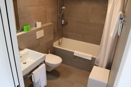 瓜尔达瓜尔达酒店的浴室配有盥洗盆、卫生间和浴缸。