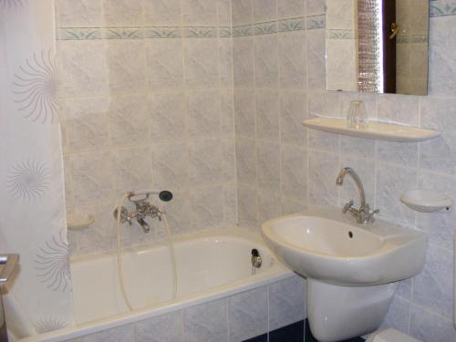 霍德梅泽瓦沙海伊Hotel Fama的一间带水槽、浴缸和卫生间的浴室