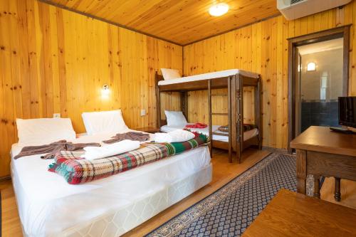 KravenikGuest Houses Apriltsi的木制客房内的一间卧室配有两张床