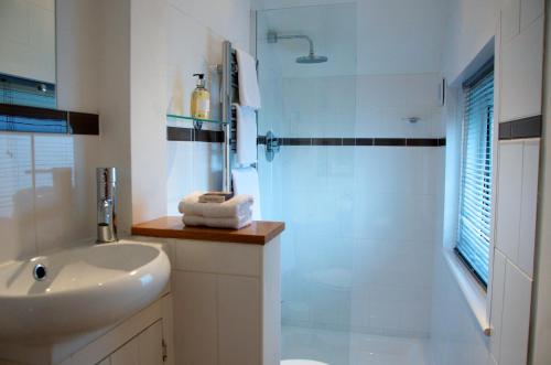 考斯一五零酒店的白色的浴室设有水槽和淋浴。