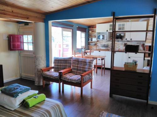 科武港A Casinha da Baía的带沙发和椅子的客厅以及厨房。