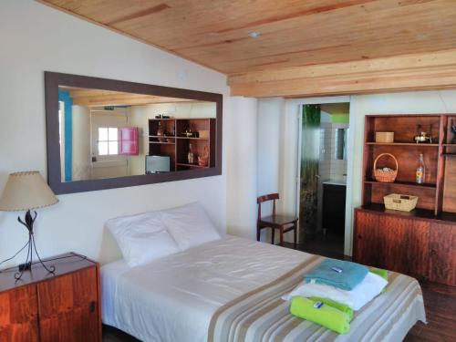 科武港A Casinha da Baía的卧室配有一张壁挂镜子的床