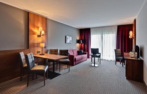 巴特朗根萨尔察Sante Royale Hotel- & Gesundheitsresort Bad Langensalza的客厅配有桌子和沙发