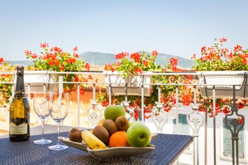 奥尔比亚中心公寓式酒店的桌上的水果盘和一瓶葡萄酒