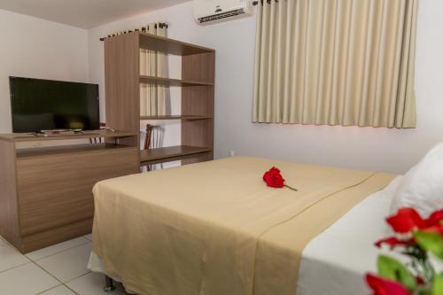 雅克南Pousada Villamor - Naturista Liberal (Adult Only)的一间卧室,床上有红玫瑰