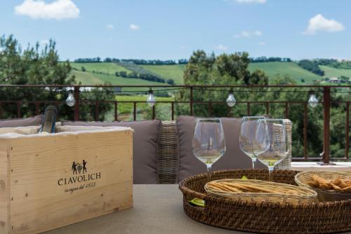 洛雷托·阿普鲁蒂诺Masseria del Vino的两杯白葡萄酒坐在桌子上,配上篮子