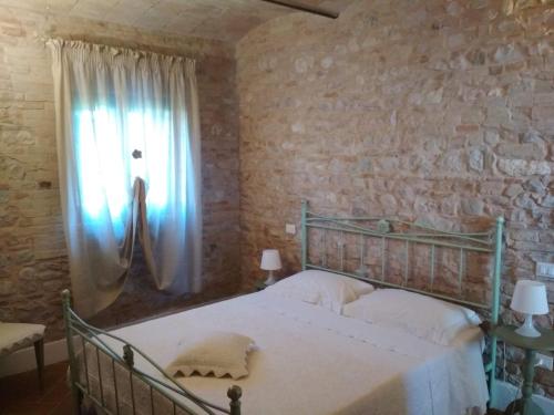 斯佩洛Podere Le Volte degli Angeli的一间卧室设有一张床和一个窗口