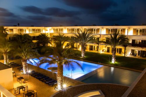 圣玛丽亚萨尔杜纳斯酒店的夜间有游泳池和棕榈树的酒店