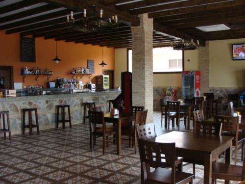 Casas del MonteApartamentos rurales Manolo的一间带桌椅的餐厅和一间酒吧