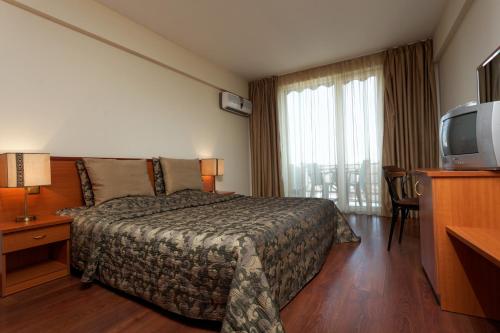 金沙Hotel Kabakum的酒店客房,配有床和电视
