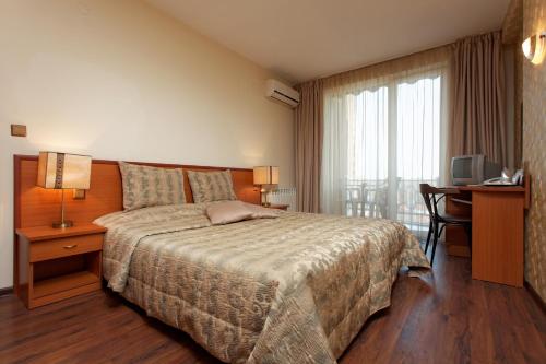 金沙Hotel Kabakum的一间卧室配有一张床、一张书桌和一台电视