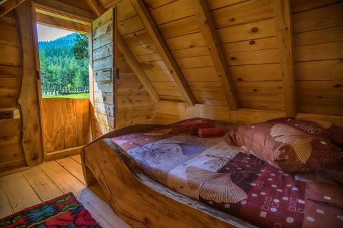 扎布利亚克Eco Camp Chalets pod Gorom的木制客房内的一张大床,设有窗户