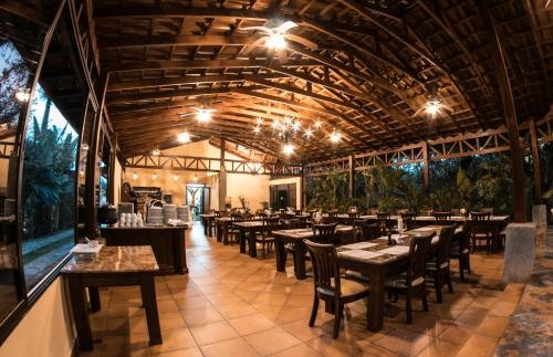 福尔图纳Paradise Hot Springs的餐厅设有木制天花板和桌椅
