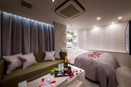 町田市小野寺休息情趣酒店（仅限成人）的一间卧室配有一张床和一张玫瑰花沙发