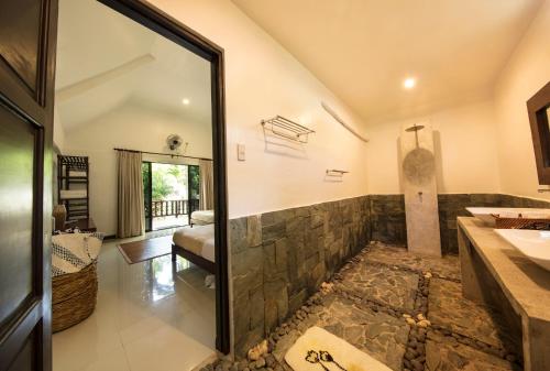 隆卡比劳圣殿海滩潜水度假村的一间带石质淋浴和水槽的浴室