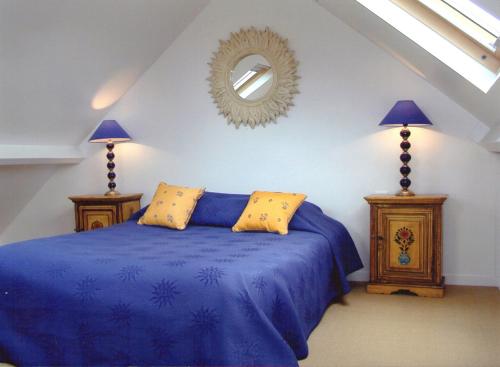 Combleux海滨公寓酒店的一间卧室配有蓝色的床和镜子
