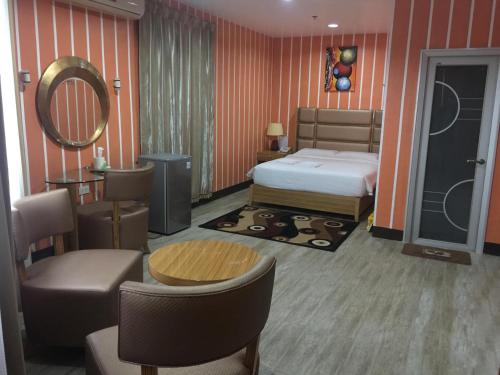 公主港吉姆克皇家酒店-巴拉望的卧室配有一张床和一张桌子及椅子