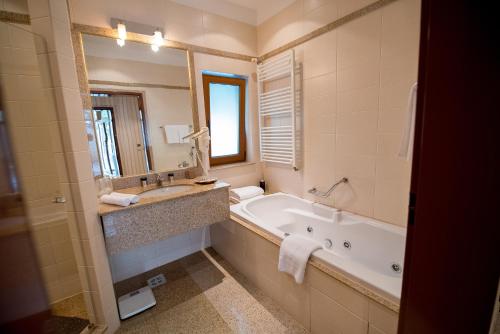 尼普顿Club de Vacanta Mediterraneo的带浴缸、水槽和镜子的浴室