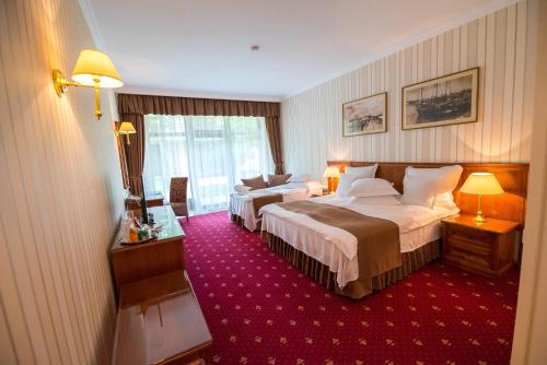 尼普顿Club de Vacanta Mediterraneo的酒店客房,设有两张床,铺有红地毯。