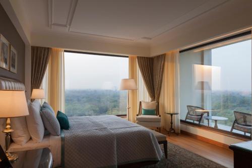 新德里新德里欧贝罗伊酒店的一间卧室设有一张床和一个大窗户