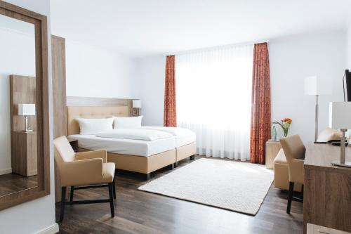宾茨宾兹米尔宅特酒店的卧室配有一张床和一张桌子及椅子