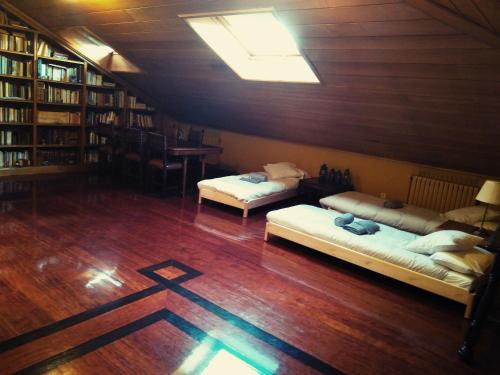 奥维多Palacete Peñanora的铺有木地板的客房内的两张床