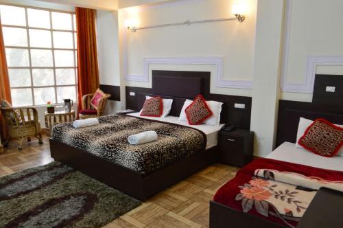 乔斯希马特Hotel Auli D的一间卧室配有两张带红色枕头的床