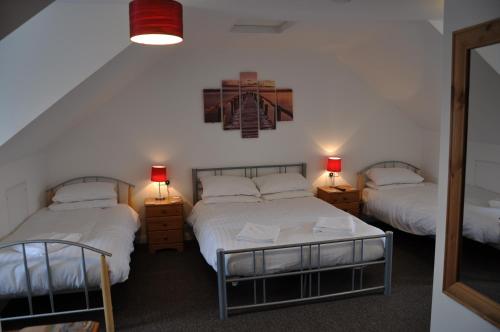 滨海克拉克顿Victoria Villa Guesthouse的一间卧室配有两张床、两盏灯和一面镜子