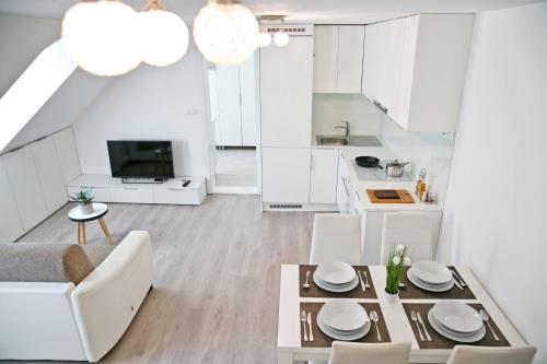 卢布尔雅那城市公寓的厨房以及带桌椅的起居室。